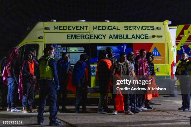 Coast Guard, Ambulance staff, Border Force and police escort asylum seekers who have just landed on Dungeness beach on an RNLI life boat late in the...