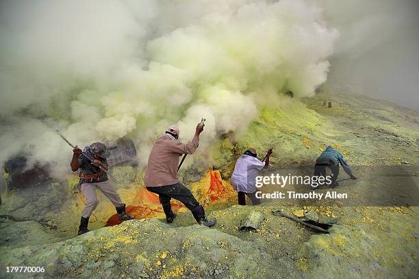 miners extract pure sulfur from volcanic crater - schwefel stock-fotos und bilder