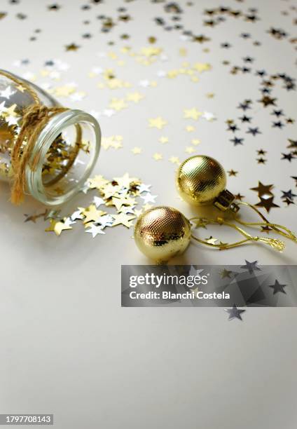 glass jar with star-shaped confetti with decorative christmas bubbles - star confetti white background stockfoto's en -beelden