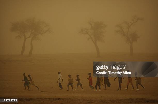 boys play football in sandstorm, djenne, mali - for freedom and peace in mali stock pictures, royalty-free photos & images
