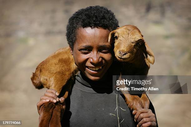 Amharic boy holding goat in Simien Mountains
