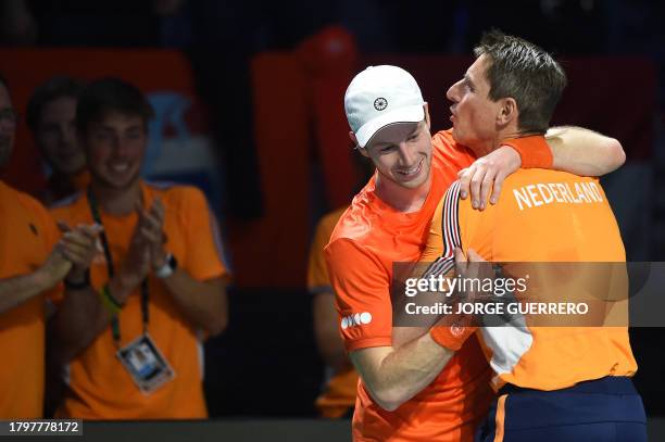 Netherlands' Botic Van de Zandschulp hugs captain Paul Haarhuis as he celebrates beating Italy's Matteo Arnaldi during the first men's single...