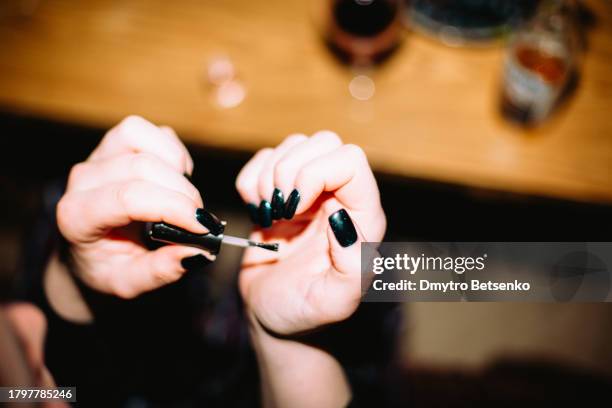 young woman painting fingernails - painting fingernails stock pictures, royalty-free photos & images