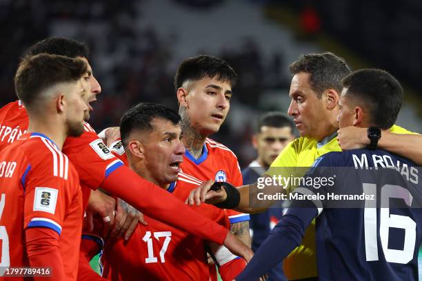 Referee Fernando Rapallini argues with Gary Medel of Chile and Matias Rojas of Paraguay during a FIFA World Cup 2026 Qualifier match between Chile...