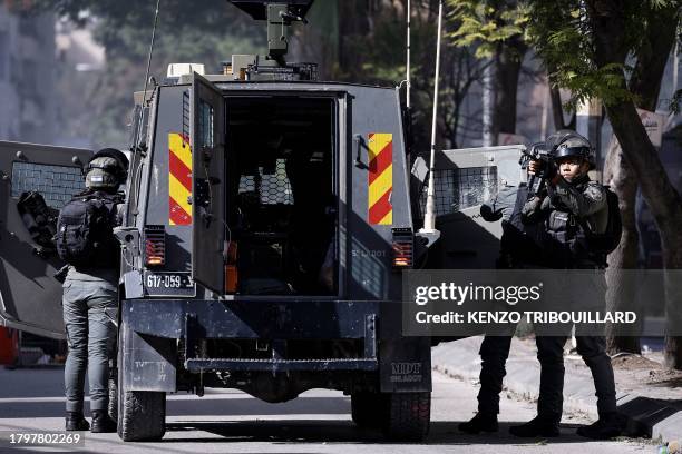 An Israeli soldier aims his rifle during a raid at the Balata camp for Palestinian refugees, east of Nablus in the occupied West Bank on November 23...