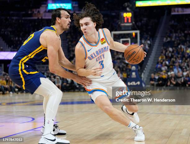 Josh Giddey of the Oklahoma City Thunder looks to drive to the basket on Dario Saric of the Golden State Warriors during the first quarter at Chase...