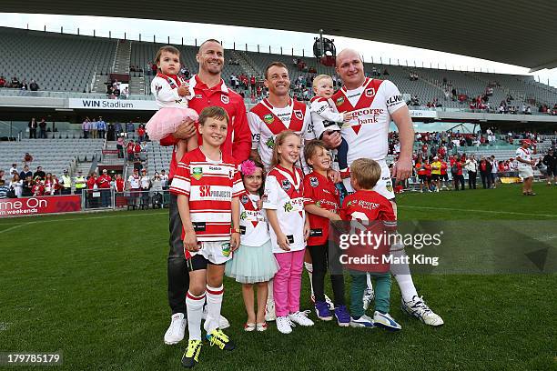 Matt Cooper, Nathan Fien and Michael Weyman of the Dragons pose with members of their families after the round 26 NRL match between the St George...