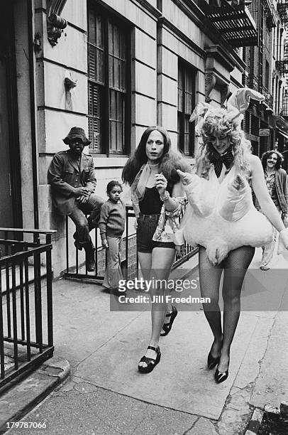 Two men in fancy dress walk on a street in Greenwich Village, New York City, 1974.