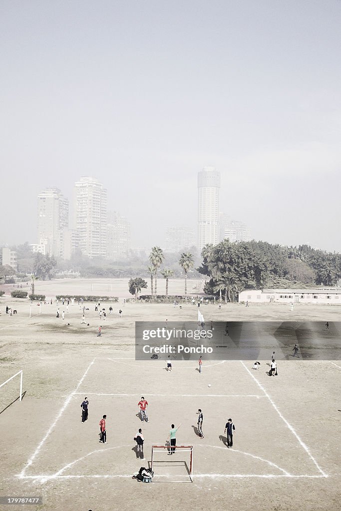 People playing football in front of Cairo skyline