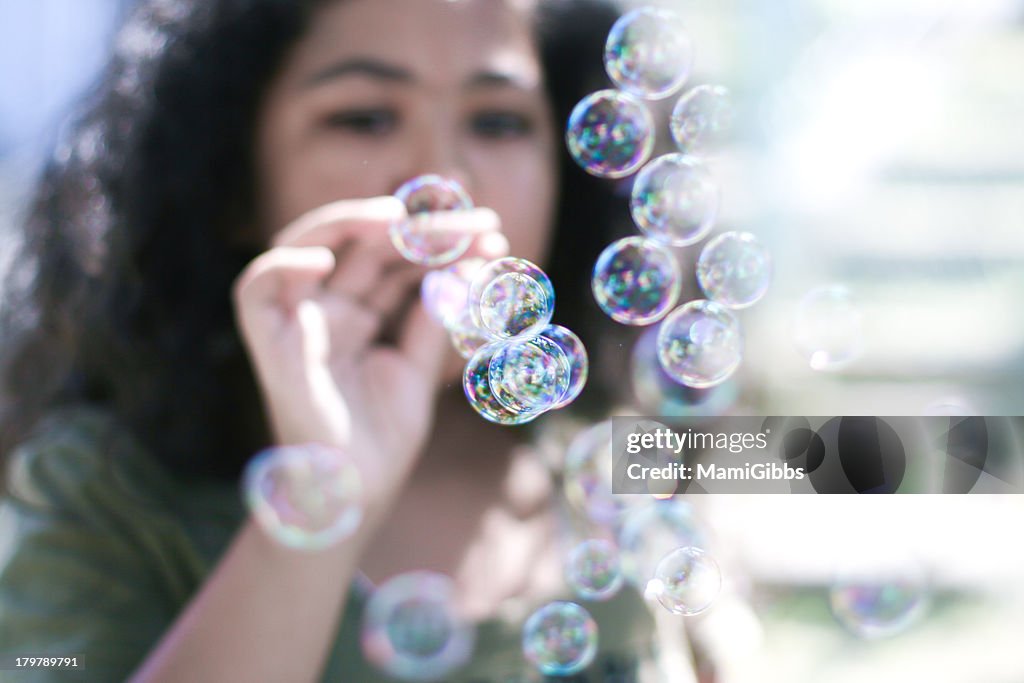 Girl playing with soap bubbles