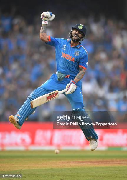 Virat Kohli of India leaps as he celebrates reaching his 50th One Day International century during the ICC Men's Cricket World Cup India 2023 Semi...