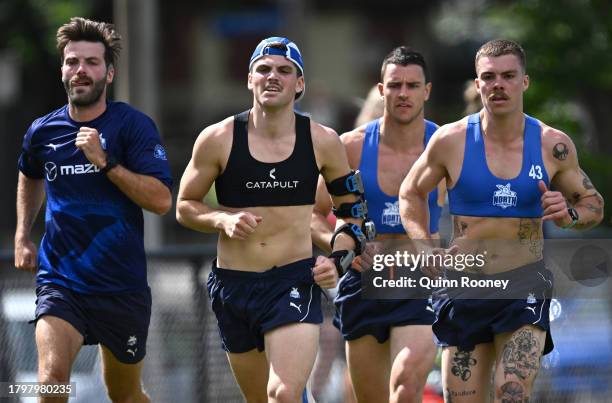 Luke McDonald, Brayden George and Luke Davies-Uniacke and Cameron Zurhaar of the Kangaroos run laps during a North Melbourne Kangaroos AFL training...