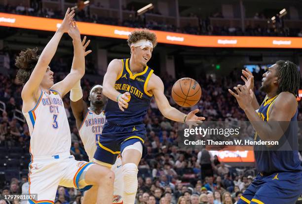 Brandin Podziemski of the Golden State Warriors passes the ball to Kevon Looney against the Oklahoma City Thunder during the fourth quarter at Chase...