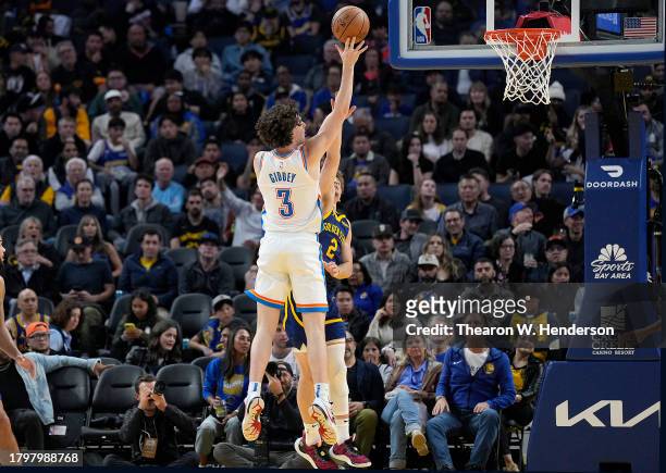 Josh Giddey of the Oklahoma City Thunder shoots over Brandin Podziemski of the Golden State Warriors during the fouth quarter at Chase Center on...