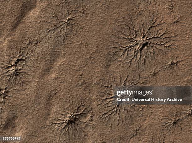 Spider-shaped features in the south polar region of Mars are carved by vaporizing dry ice in a dynamic seasonal process. Mars Reconnaissance Orbiter.