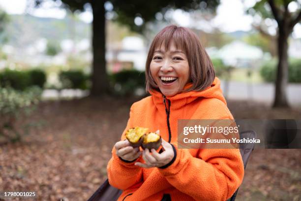 people gathered at an agricultural harvest festival held in a suburban park. - asian woman roasted stock pictures, royalty-free photos & images
