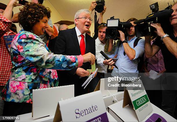 Kevin Rudd, Australia's prime minister and leader of the Labor Party, center, reacts as he prepares to cast his ballot while his wife Therese Rein,...