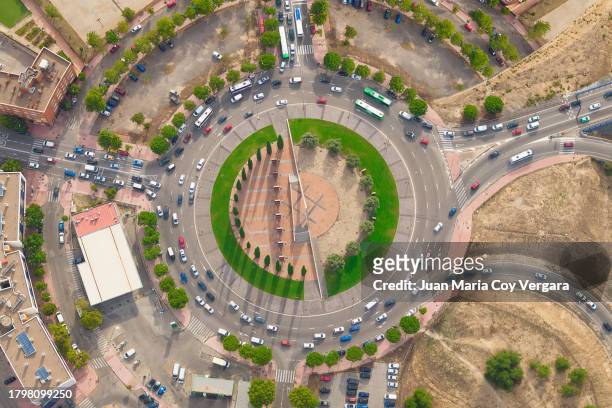 aerial view of car traffic at circle roundabout intersection with fast moving heavy traffic. urban circular transportation crossroads at day, time lapse, spain - traffic time lapse stock pictures, royalty-free photos & images