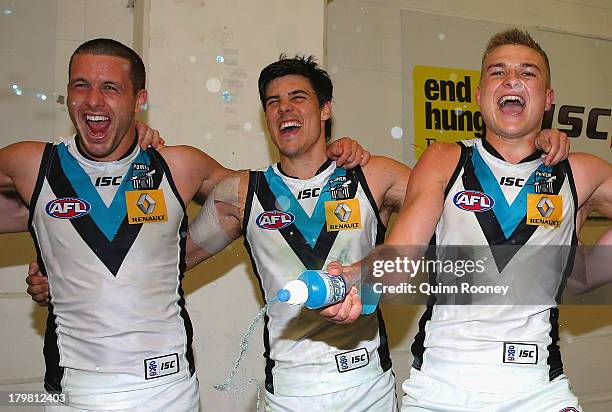 Travis Boak, Angus Monfries and Oliver Wines of the Powersing the song in the rooms after winning the Second AFL Elimination Final match between the...