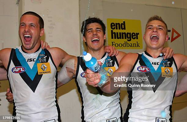 Travis Boak, Angus Monfries and Oliver Wines of the Powersing the song in the rooms after winning the Second AFL Elimination Final match between the...
