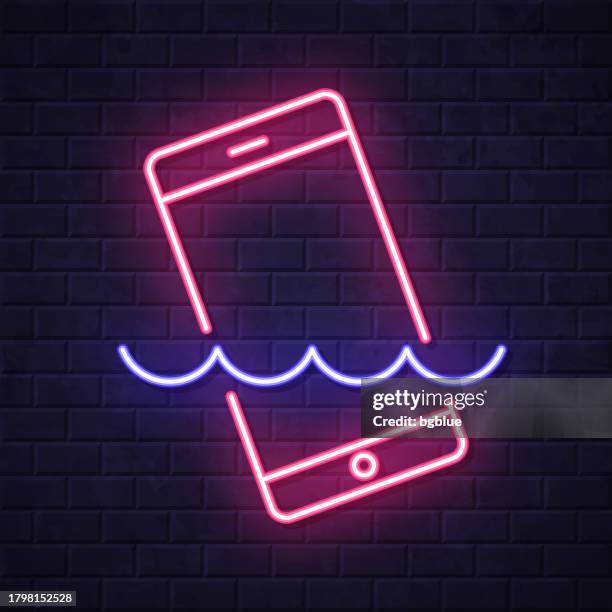 smartphone in water. glowing neon icon on brick wall background - touch screen wall stock illustrations