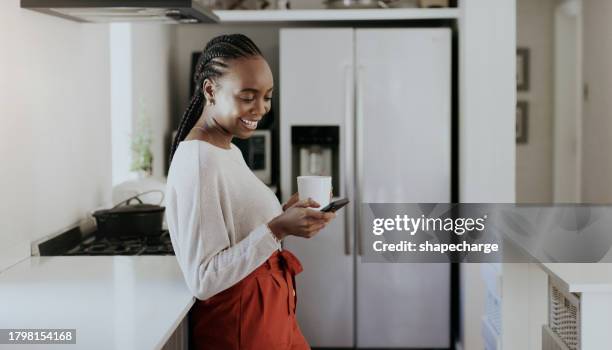 mujer, café o escribir en el smartphone en la cocina para la red social, actualizar la suscripción multimedia o buscar en la web. chica africana feliz bebiendo té, descargue la aplicación móvil o la notificación de lectura en casa - suscripción fotografías e imágenes de stock