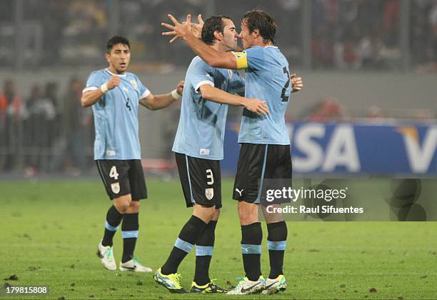 Diego Lugano and Diego Godin of Uruguay celebrates at the end of a match between Peru and Uruguay as part of the 15th round of the South American...