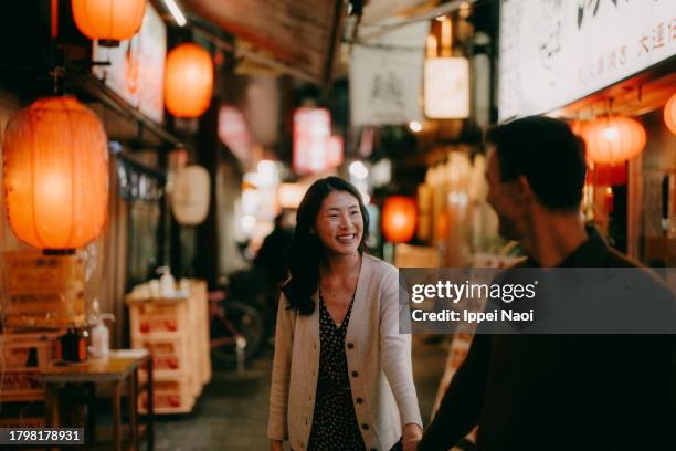 woman having a good time with her boyfriend in tokyo at night - préfecture-de-tokyo photos et images de collection