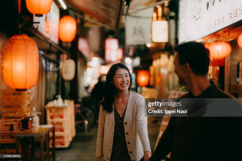 Woman having a good time with her boyfriend in Tokyo at night