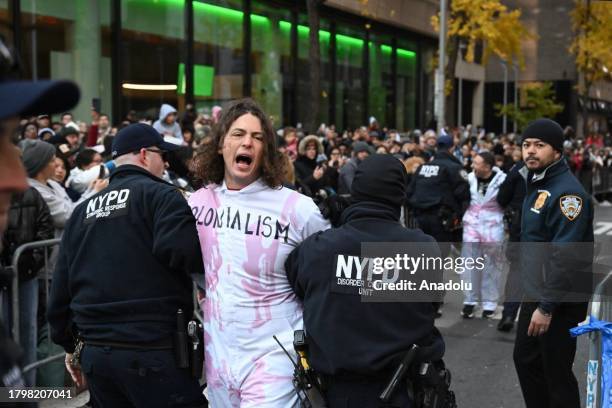 New York Police Department members intervene and take two pro-Palestinian protesters into custody, who entered the parade, during the traditional...