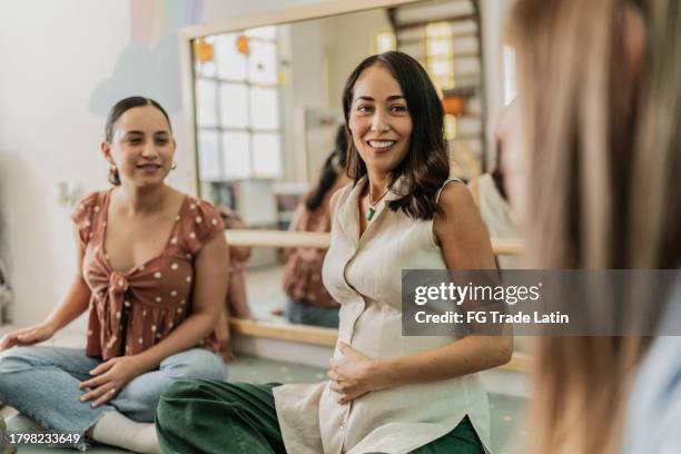 pregnant woman talking to other mothers in a support group - reünie sociaal stockfoto's en -beelden