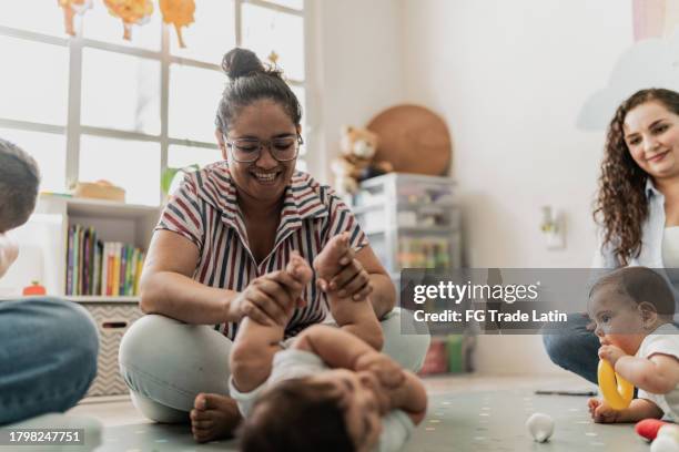 madre jugando con su bebé en la sala de juegos - vida de bebé fotografías e imágenes de stock
