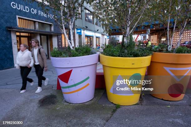 People interacting with large scale flower pot outside on Southwark Street on 15th November 2023 in London, United Kingdom.