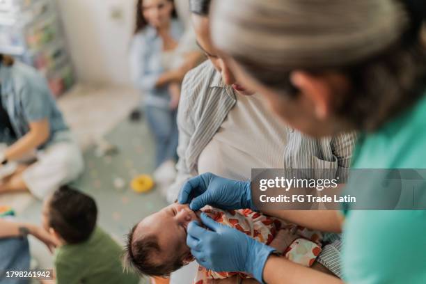 nurse helping a mother to breastfeed in the support group - midwifery stock pictures, royalty-free photos & images