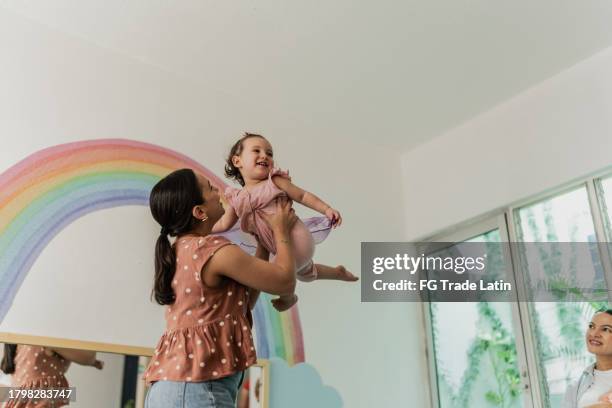 mid adult mother playing with her daughter in the playroom - playroom stock pictures, royalty-free photos & images