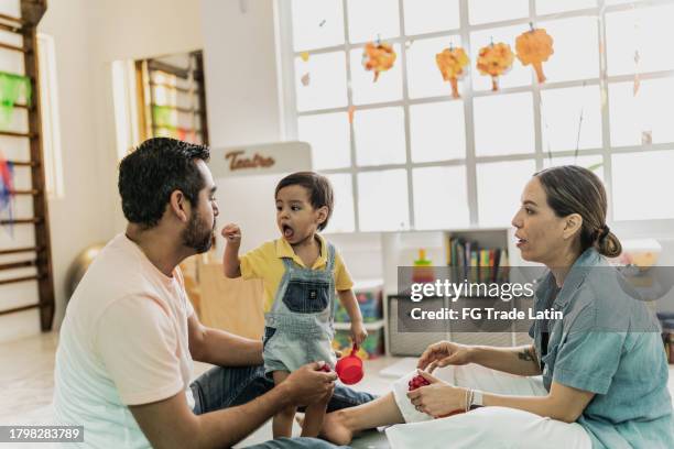 family playing together in the playroom - playroom stock pictures, royalty-free photos & images