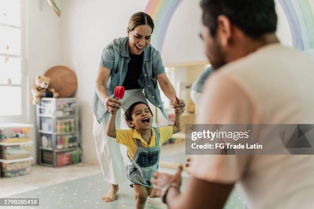 toddler boy playing with his parents in the playroom - primeiros passos imagens e fotografias de stock