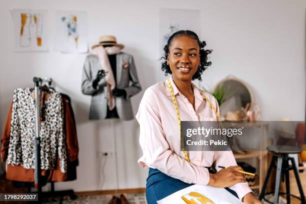 portrait of smiling beautiful clothing designer at tailor workshop - mode ontwerper stockfoto's en -beelden