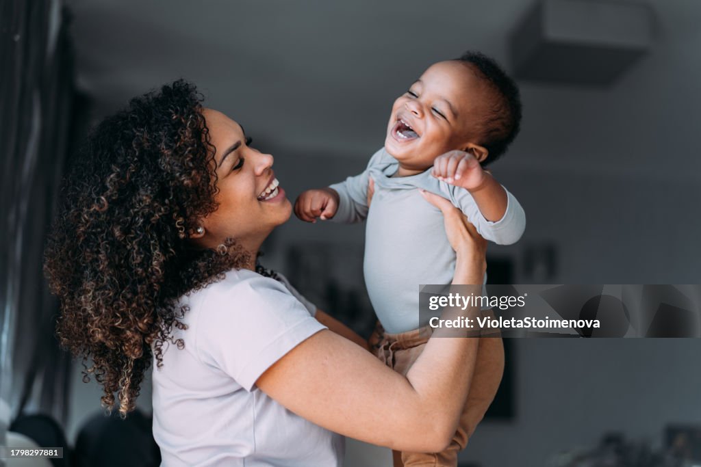 Mother and cute baby boy having fun at home.