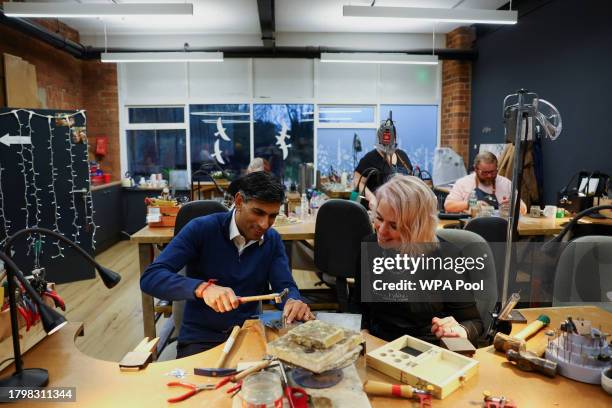 British Prime Minister Rishi Sunak, next to Emma White, hammers a piece of jewellery during a meeting with small business owners from Sunny Bank...