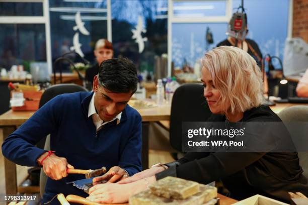 British Prime Minister Rishi Sunak, next to Emma White, hammers a piece of jewellery during a meeting with small business owners from Sunny Bank...