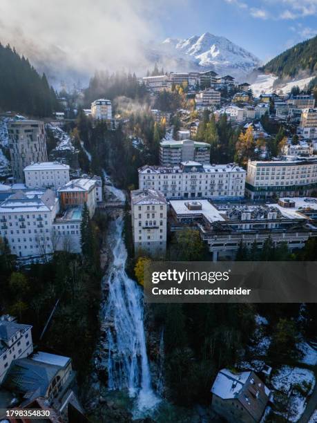 aerial autumnal cityscape with a snow covered mountain backdrop, bad gastein, st johann im pongau, salzburg, austria - bad gastein stockfoto's en -beelden