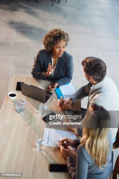 vista sopra dell'agente assicurativo che parla con i suoi clienti in ufficio. - cliente foto e immagini stock