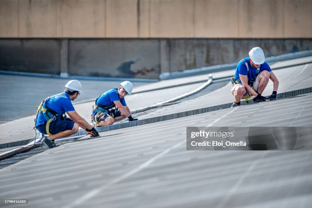 Team of three engineers installing solar panels