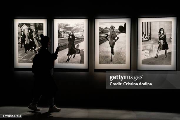 Woman takes photos with her mobile phone during the press conference at the opening of the exhibition Helmut Newton - Fat & Fiction at the Muelle de...