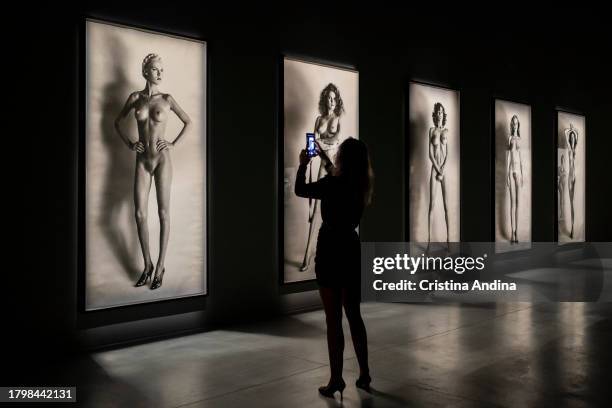 Woman looks at a photograph during the press conference at the opening of the exhibition Helmut Newton - Fat & Fiction at the Muelle de Batería in A...