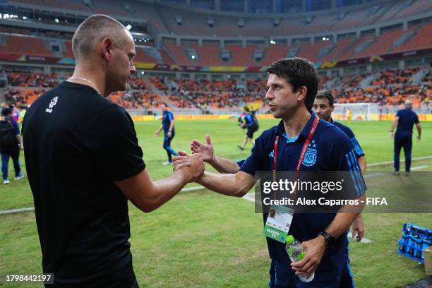 Marcin Wlodarski, Head Coach of Poland, and Diego Placente, Head Coach of Argentina, shake hands after the Group E match between Poland and Argentina...