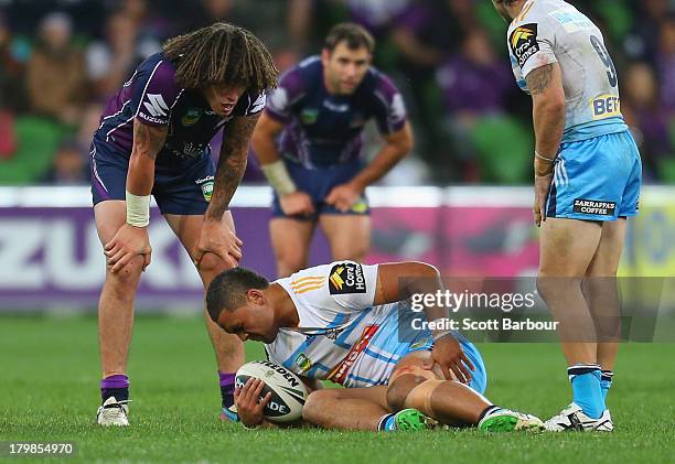 Mark Ioane of the Titans reacts after being tackled by Kenneath Bromwich of the Storm during the round 26 NRL match between the Melbourne Storm and...