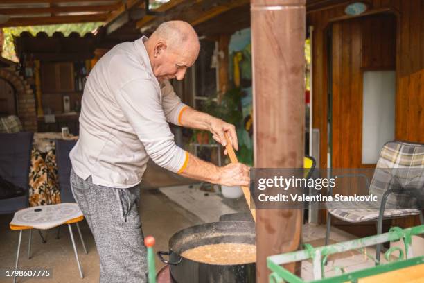 stirring a big pot of lard - big fat white women 個照片及圖片檔