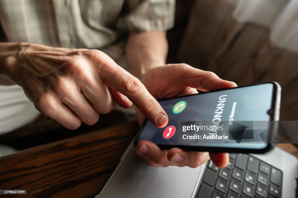 Senior man refuses to answer to a call from unknown number. Scam and fraud prevention with smartphone concept.